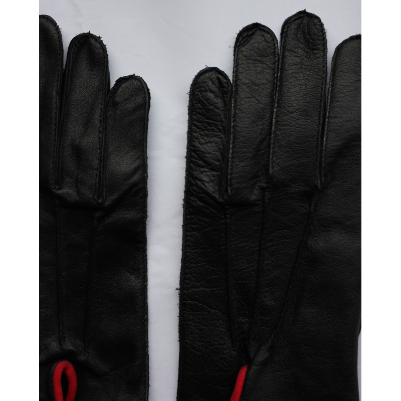 Gros plan du dos de gants en cuir noir : nervures et coutures des doigts