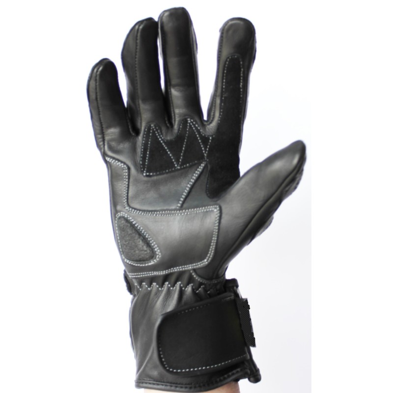 Paume d’un gant de moto en cuir noir portée, coutures blanches et manchette à scratch