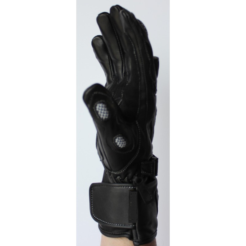Profil d’un gant de moto en cuir noir porté, pouce renforcé et patte de manchette
