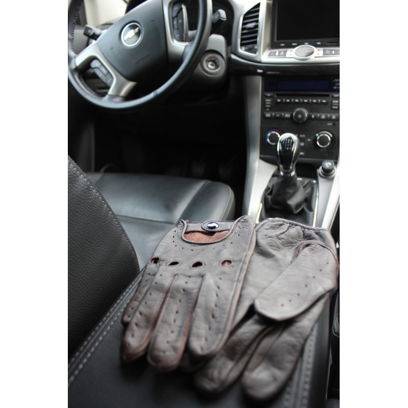Gants de conduite en cuir marron posés sur un siège de voiture