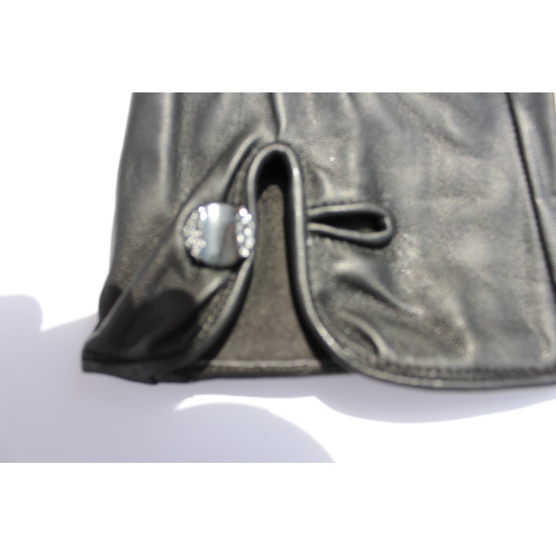 Détail du poignet : bouton fantaisie et bride sur un gant en cuir noir