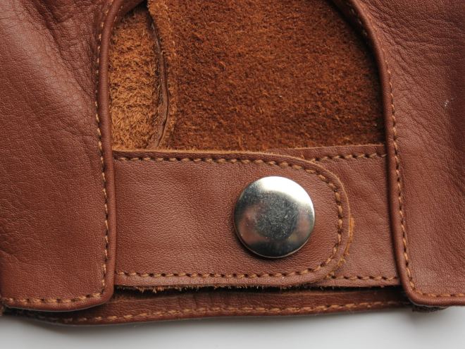 Poignet de gant en cuir fauve : surpiqûres, pression et doublure en croûte de cuir